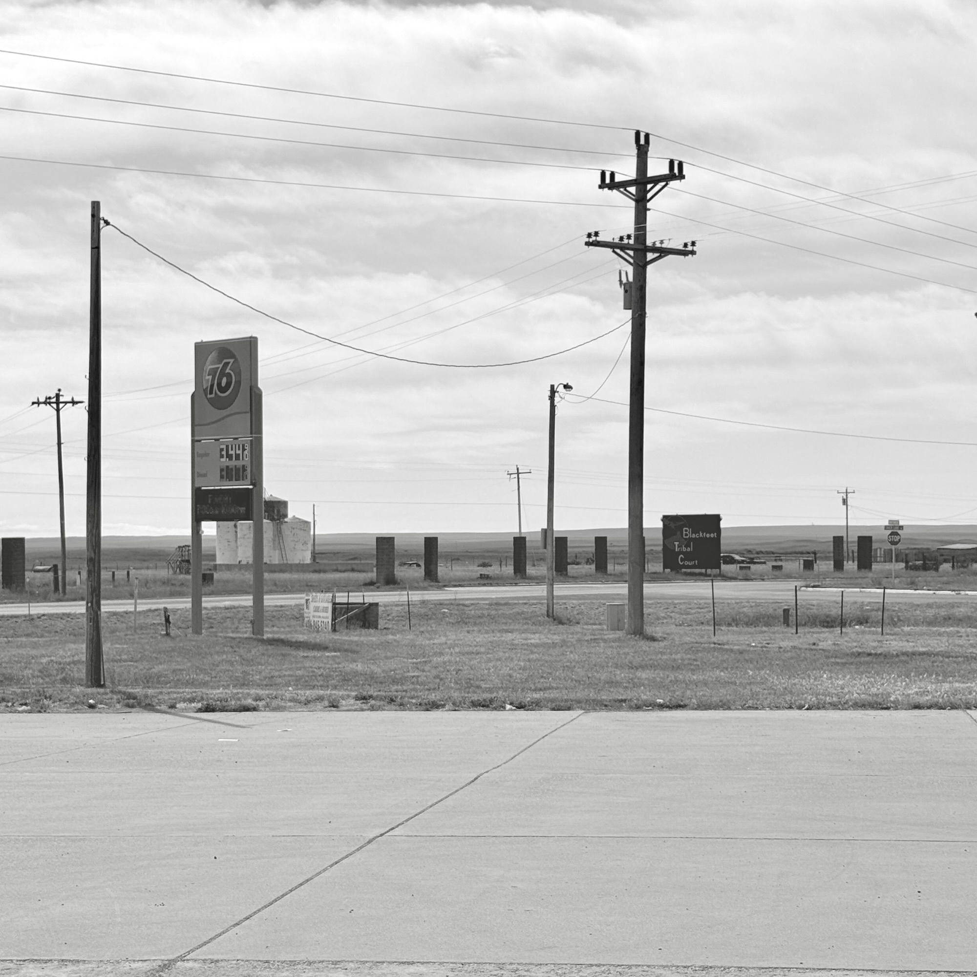 Gas station and power lines against backdrop of flat plain